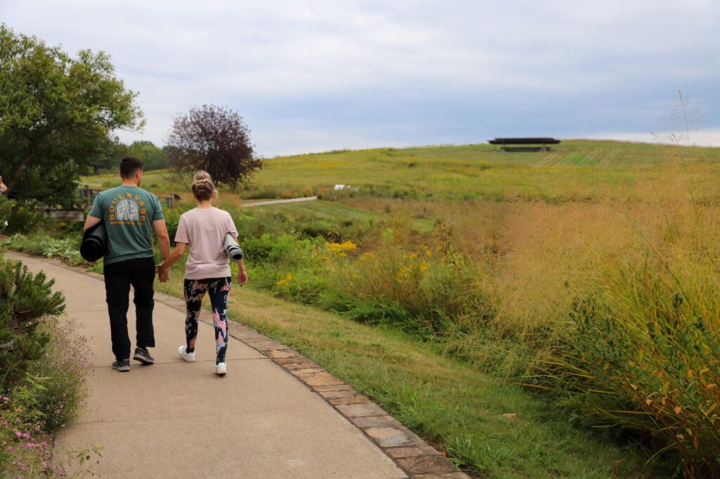 Man and woman walk away from the camera along one of Powell Gardens' paths.